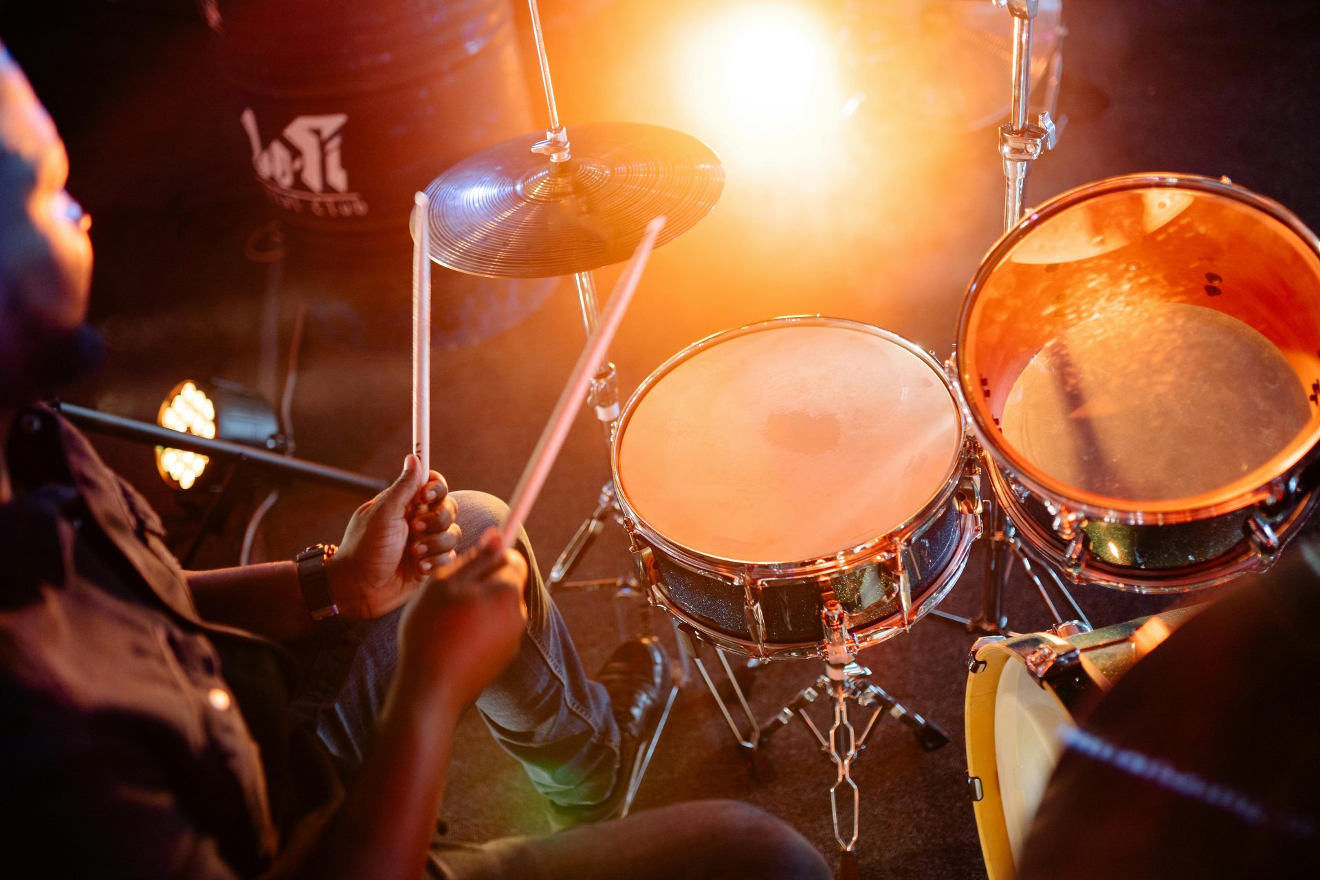 Drummer playing passionately with glowing stage lights