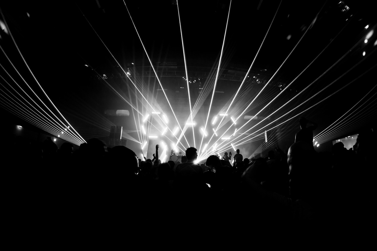 Laser lights illuminating a dark concert venue scene