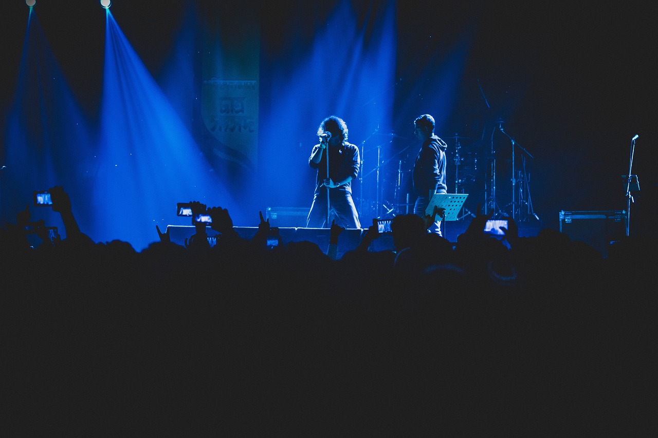 Artist singing onstage under striking blue lights