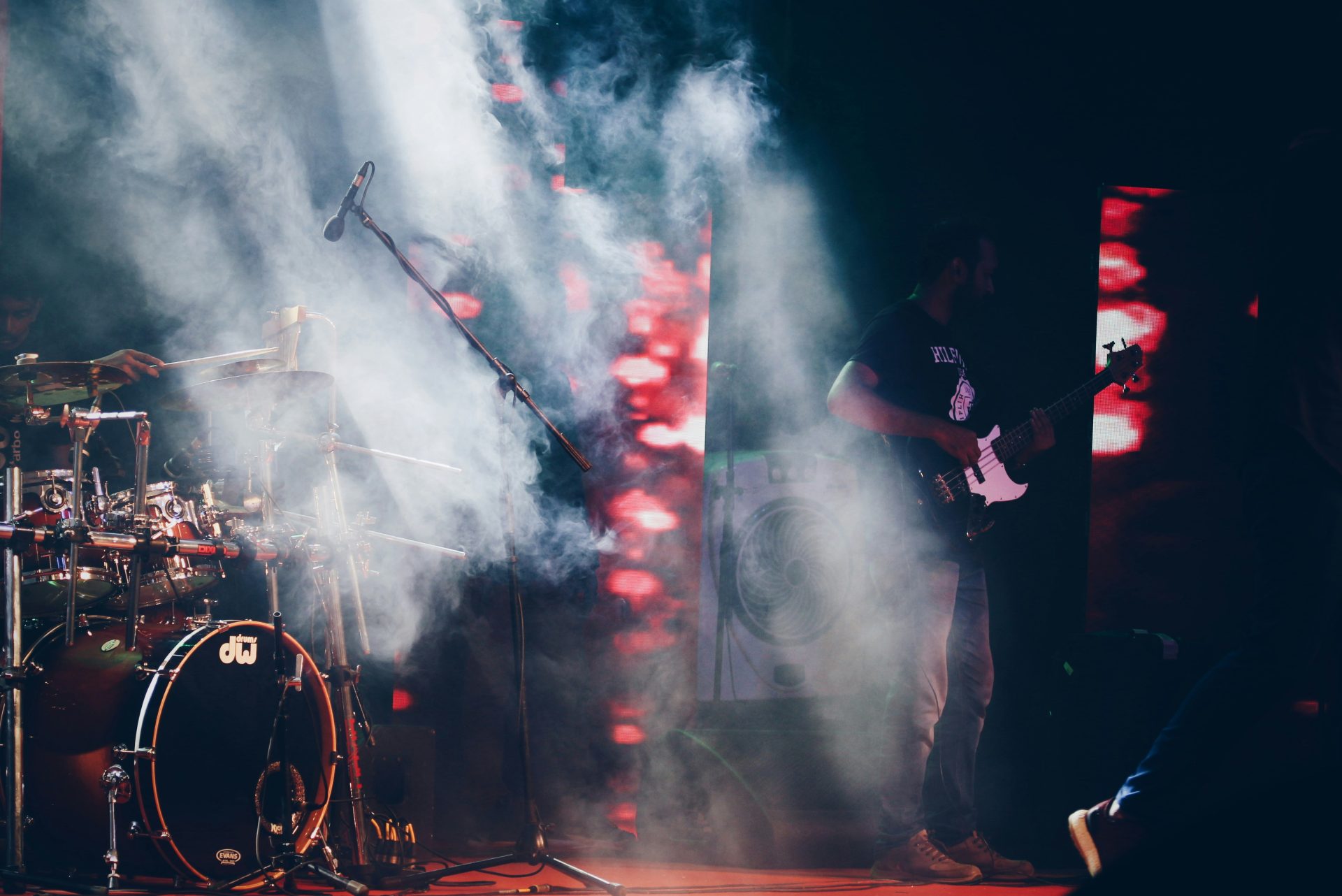 Guitarist performing live surrounded by mist and lights